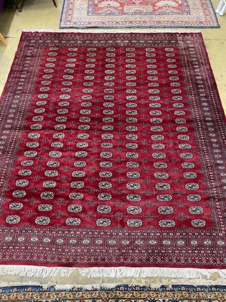 A Bokhara burgundy ground carpet, 284 x 244cm